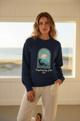 Navy blue sweatshirt with a graphic of a person by the sea on a white background