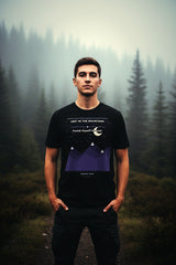 Person wearing a black t-shirt with a design in a forest setting